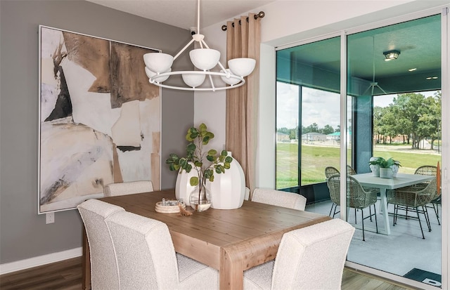 dining space featuring hardwood / wood-style flooring and a notable chandelier