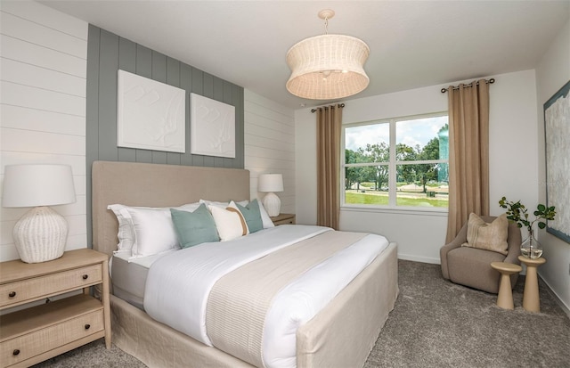 carpeted bedroom featuring wood walls