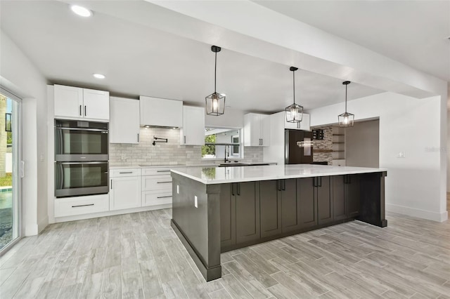 kitchen featuring white cabinetry, pendant lighting, and a large island