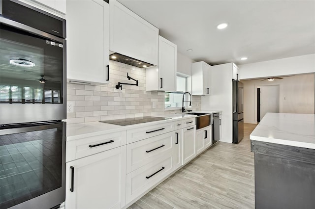 kitchen featuring sink, white cabinets, stainless steel appliances, and light wood-type flooring