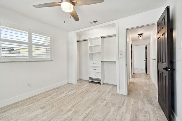 unfurnished bedroom featuring a closet, light hardwood / wood-style floors, and ceiling fan