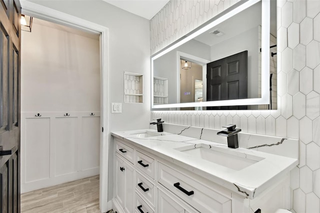 bathroom featuring wood-type flooring, vanity, and tasteful backsplash