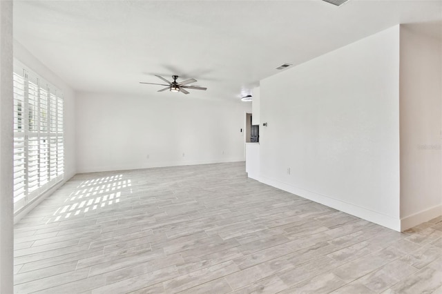 empty room with ceiling fan and light wood-type flooring