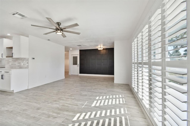 spare room with light wood-type flooring and ceiling fan