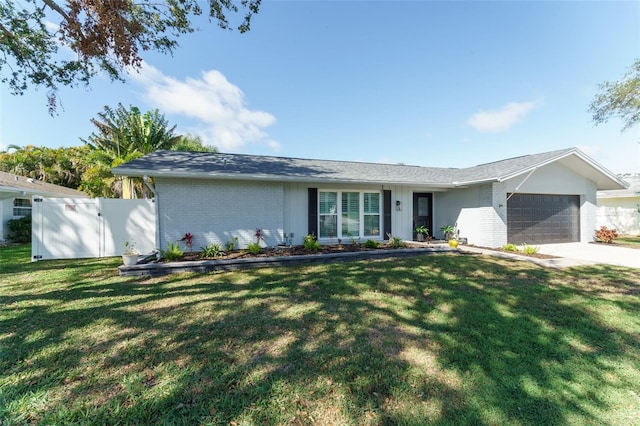 single story home with brick siding, fence, a garage, driveway, and a front lawn