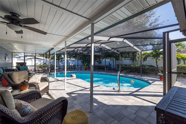 view of swimming pool featuring ceiling fan, a lanai, an outdoor living space, and a patio