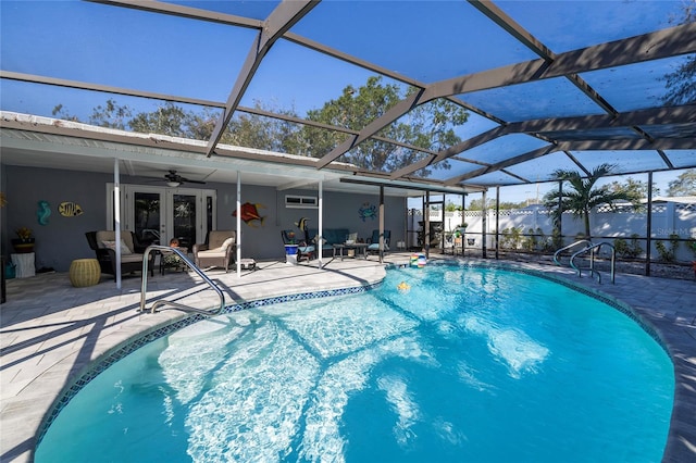 view of swimming pool with a lanai, ceiling fan, french doors, and a patio