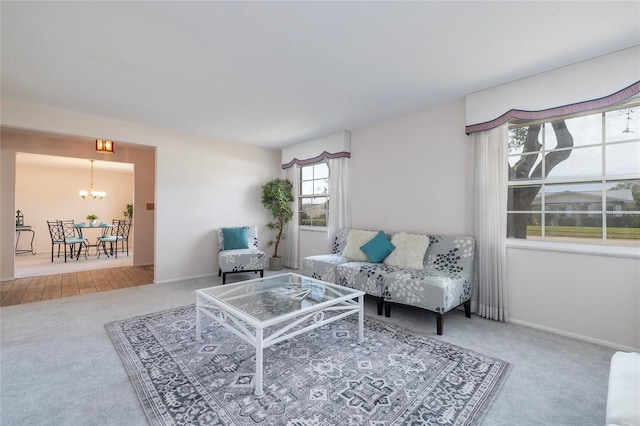 carpeted living room with a notable chandelier