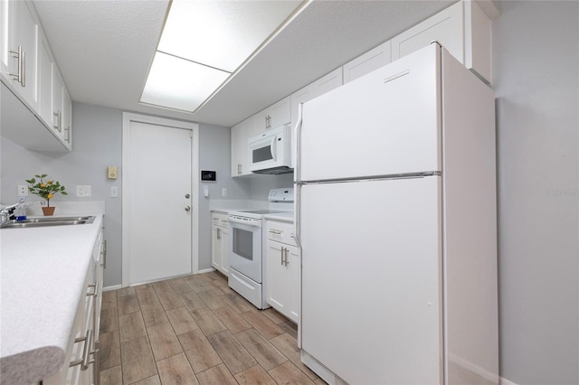 kitchen with sink, white appliances, and white cabinets