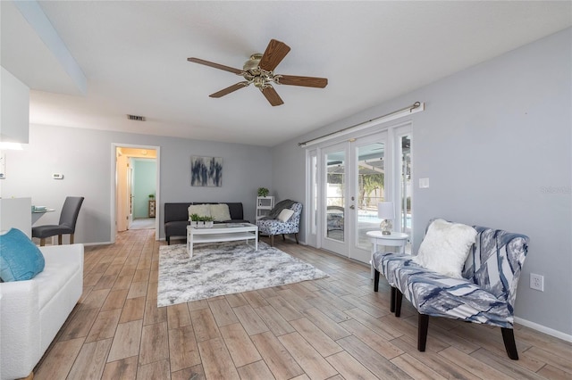 living room featuring ceiling fan, french doors, and light hardwood / wood-style floors