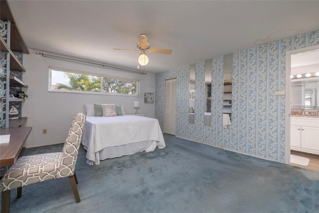 carpeted bedroom featuring ensuite bathroom, ceiling fan, sink, and a closet