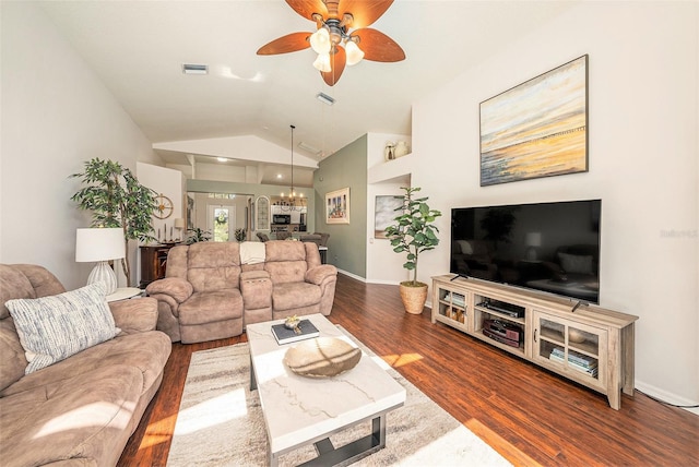 living room with lofted ceiling, dark wood-type flooring, and ceiling fan with notable chandelier