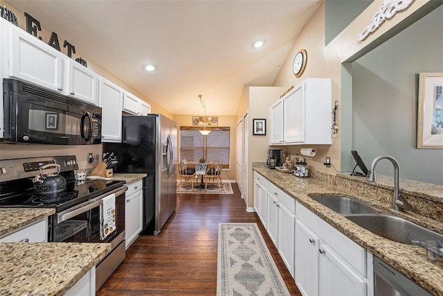 kitchen with white cabinetry, light stone counters, stainless steel appliances, and dark hardwood / wood-style floors