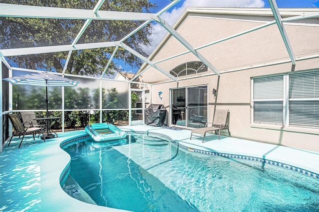 view of pool featuring a patio and glass enclosure