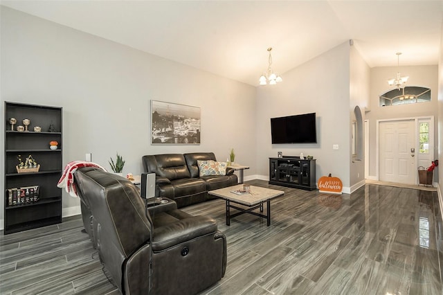 living room with dark hardwood / wood-style flooring, a notable chandelier, and vaulted ceiling