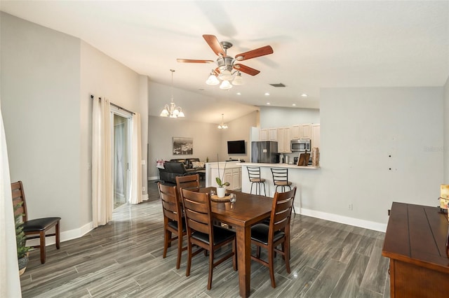 dining space with ceiling fan with notable chandelier, vaulted ceiling, and dark hardwood / wood-style floors