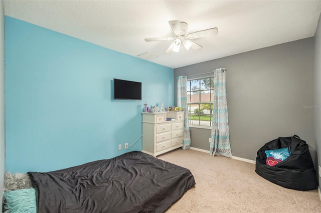 bedroom with light carpet, a textured ceiling, and ceiling fan