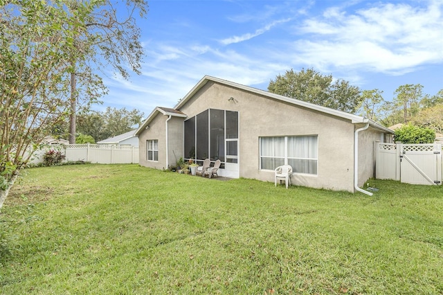 rear view of property with a yard and a sunroom