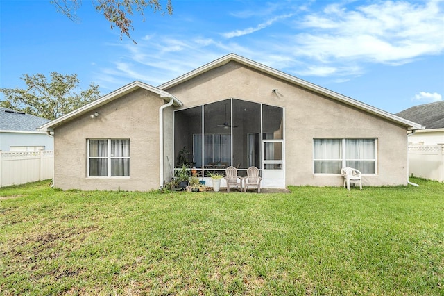 rear view of house with a lawn and a sunroom