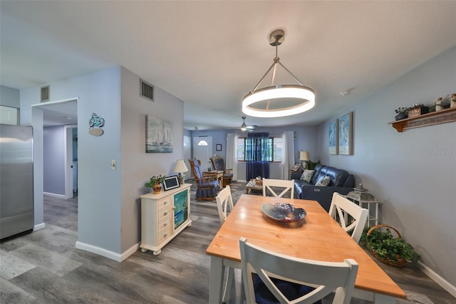 dining room with ceiling fan and dark hardwood / wood-style flooring