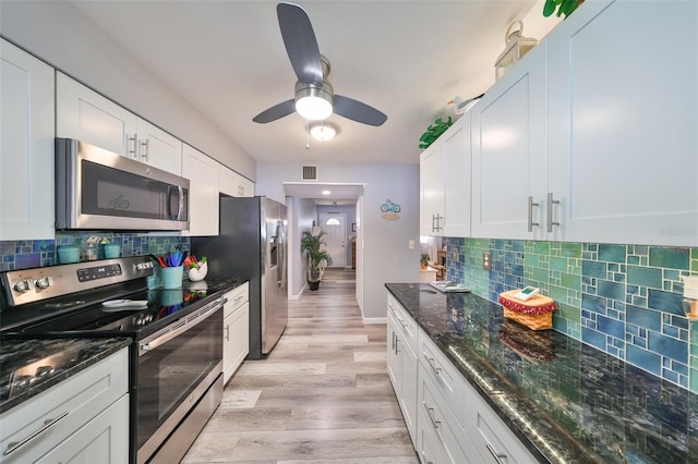 kitchen featuring white cabinets, light hardwood / wood-style flooring, stainless steel appliances, and backsplash