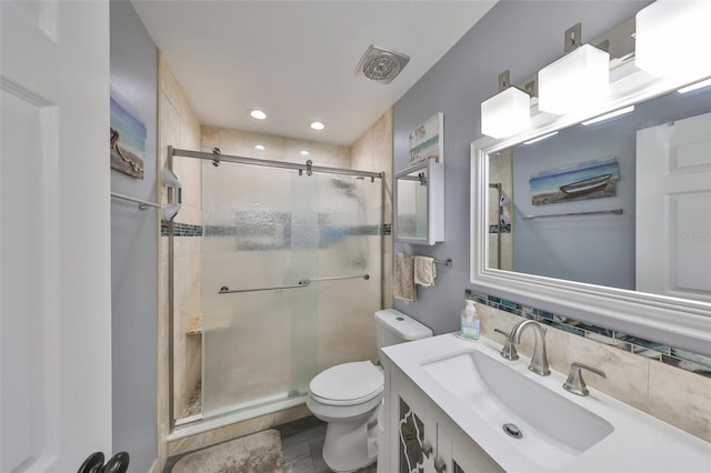 bathroom with vanity, decorative backsplash, a shower with shower door, and toilet