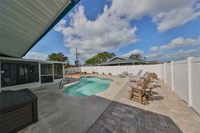 view of swimming pool featuring a patio and a sunroom