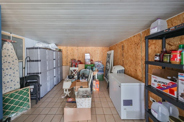 laundry room with wood walls and light tile patterned floors