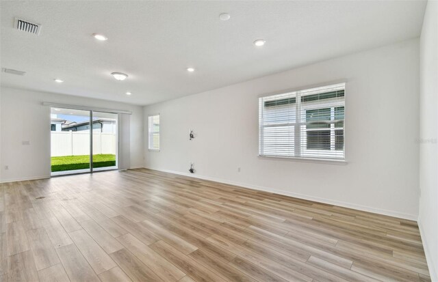 unfurnished room with recessed lighting, baseboards, visible vents, and light wood finished floors