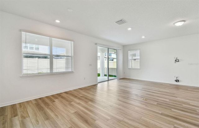 empty room with light wood finished floors, baseboards, visible vents, and recessed lighting