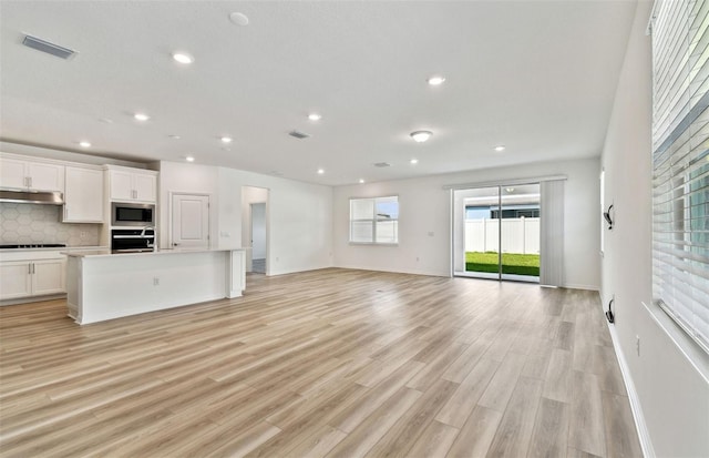 unfurnished living room with light wood-style floors, recessed lighting, visible vents, and baseboards