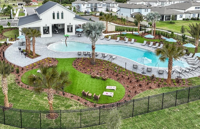 pool featuring a residential view, fence, a lawn, and a patio