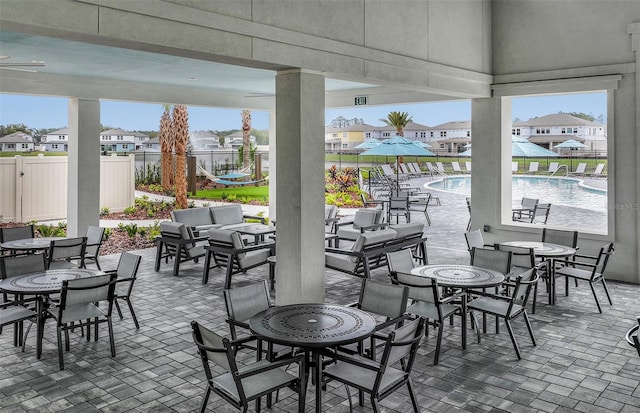 view of patio / terrace featuring a residential view, fence, and a community pool