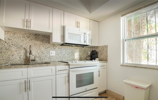 kitchen featuring sink, light stone counters, backsplash, white appliances, and white cabinets