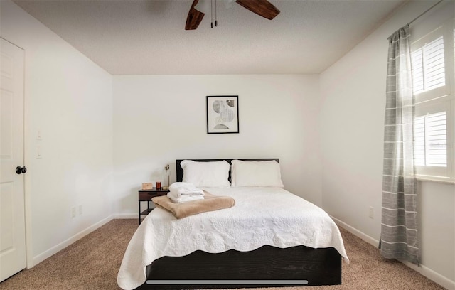 bedroom with ceiling fan, a textured ceiling, and carpet