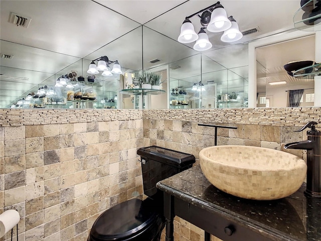 bathroom with vanity, toilet, and backsplash