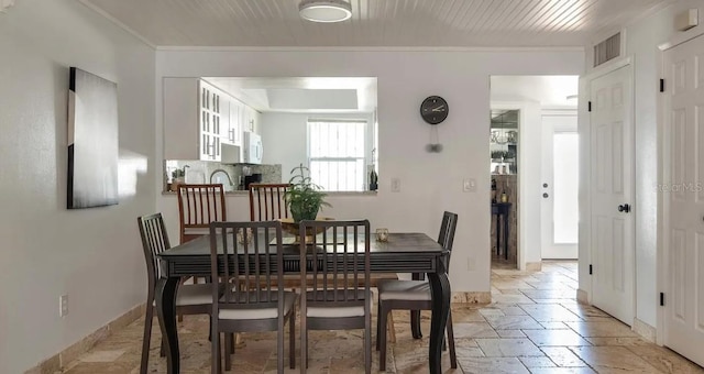 dining area featuring crown molding