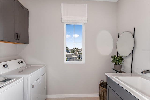 laundry room featuring cabinets, sink, and separate washer and dryer