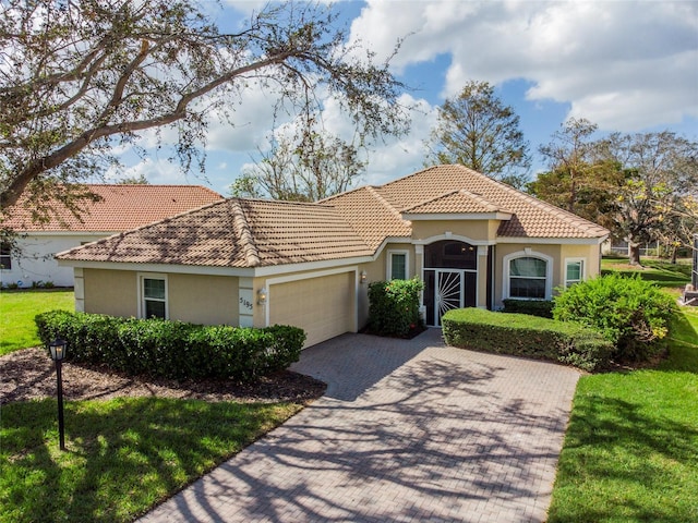 5195 Highbury Cir, Sarasota, FL 34238 - mediterranean / spanish home with a tile roof, a garage, stucco siding, a front yard, and decorative driveway