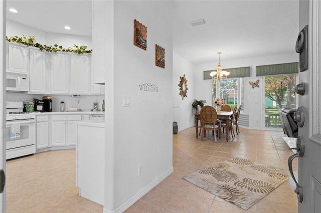 kitchen with white cabinets, light tile patterned floors, a notable chandelier, decorative light fixtures, and white appliances