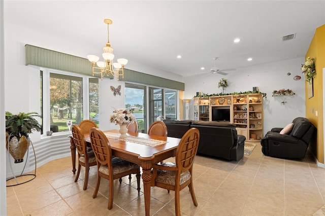 dining room with light tile patterned flooring and ceiling fan with notable chandelier