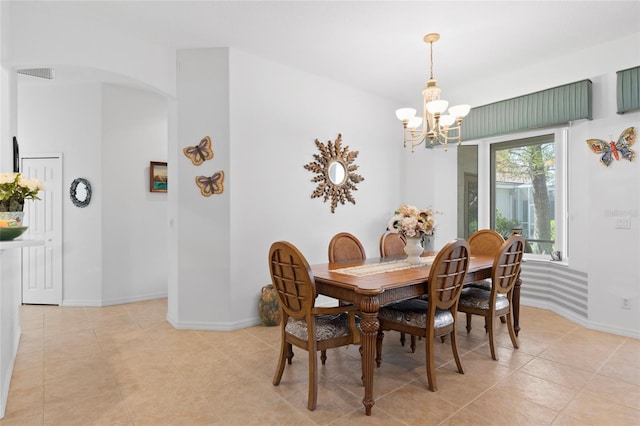 dining space with light tile patterned flooring and a chandelier