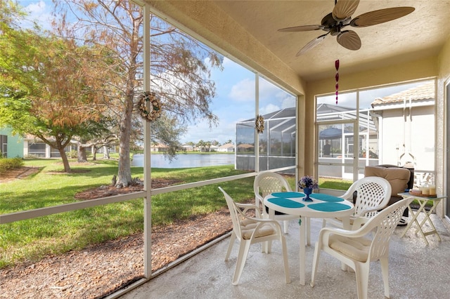 sunroom / solarium featuring a water view and ceiling fan