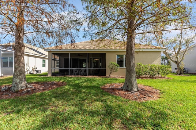 5195 Highbury Cir, Sarasota, FL 34238 - rear view of house featuring a tiled roof, a ceiling fan, a sunroom, a yard, and stucco siding