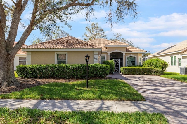 5195 Highbury Cir, Sarasota, FL 34238 - mediterranean / spanish house featuring a tiled roof, cooling unit, and stucco siding