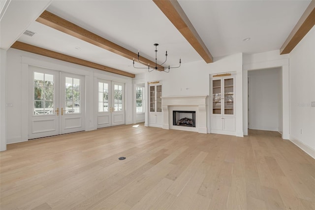 unfurnished living room featuring beam ceiling, french doors, and light hardwood / wood-style flooring