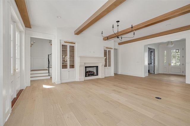 unfurnished living room featuring light hardwood / wood-style flooring and beam ceiling