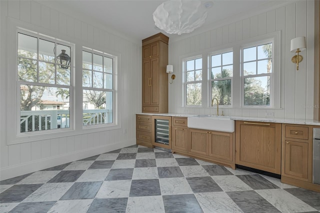 bar with plenty of natural light, sink, and beverage cooler