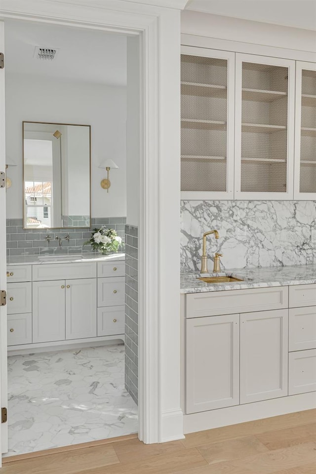 interior space featuring sink, white cabinetry, and light hardwood / wood-style flooring