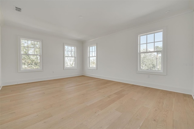 unfurnished room with crown molding and light hardwood / wood-style flooring